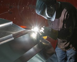 man welding an aluminum boat hull