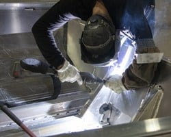 man welding a boat together